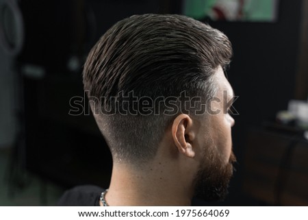 Low fade machine haircut for handsome bearded man in barbershop. Hair cut with a smooth transition Royalty-Free Stock Photo #1975664069