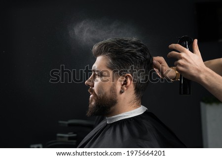 Barber making hairstyle for confident bearded hipster. Advertising for barbershop and men's beauty salon Royalty-Free Stock Photo #1975664201