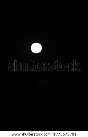 a full white moon shining bright in the night sky