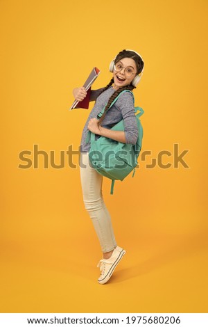 Music school. Happy girl back to school. Schoolchild carry backpack yellow background. School and education. Knowledge day. September 1. Startup. First day of school. Always learning