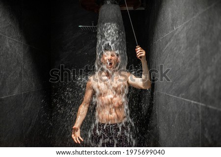 Man hardening with bucket of ice cold water after hot sauna, healthy lifestyle and cold training concept. Wellness and spa. Royalty-Free Stock Photo #1975699040