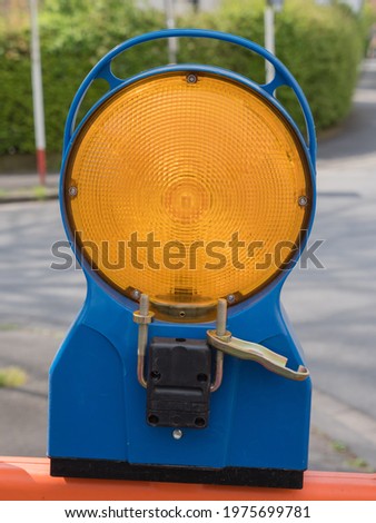 Close up warning light with blue bracket at a construction site

