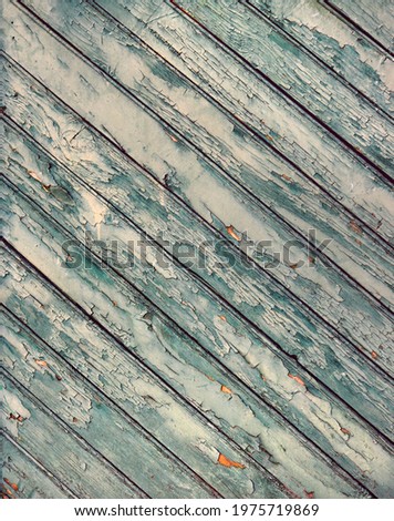 weathered wooden surface from a door with oblique boards, green and yellow peeling painting and rough texture Royalty-Free Stock Photo #1975719869