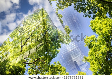 green city - double exposure of lush green forest and modern skyscrapers windows	 Royalty-Free Stock Photo #1975731359