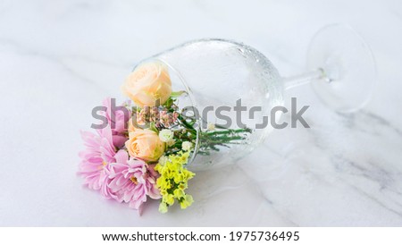Delicate small bouquet of flowers in a lying glass. Image with selective focus
