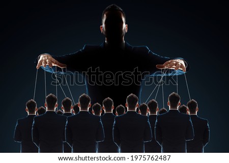 A man, a puppeteer, controls the crowd with threads. The concept of world conspiracy, world government, manipulation, world control Royalty-Free Stock Photo #1975762487