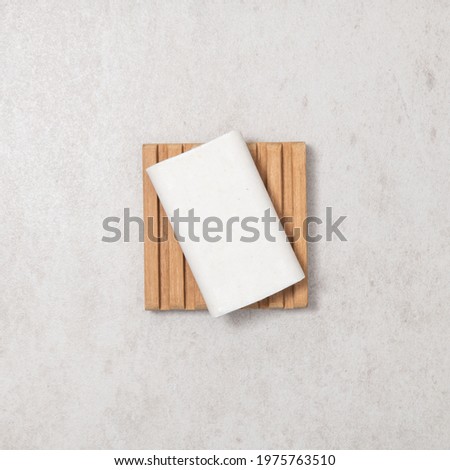 Natural eco friendly handmade soap bar on wooden dish on beige background. Zero waste, plastic free. Solid shampoo. Self care or cleaning minimal concept. Top view, flat lay, mockup for design.