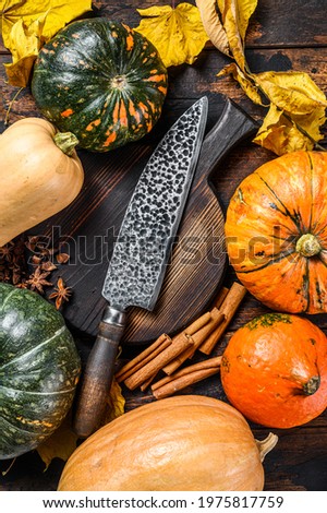 Food composition with pumpkins, knife and cutting board. Dark Wooden background. Top view