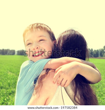 Toned photo of Happy Kid and Mother at the Summer Field