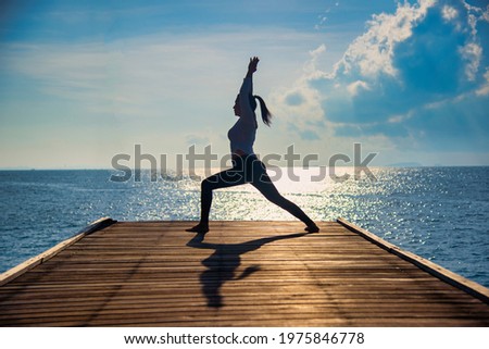 Young healthy woman practicing Yoga on the bridge in the nature. Healthy Concept.