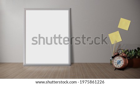 Wooden desk with photo frame and minimal round vase with a decorative twig against white wall