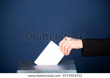 Voter putting vote in the ballot box. Election concept.