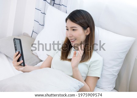 Asian woman using smartphone for video call, looking at screen of smartphone, Modern technologies and communication.
