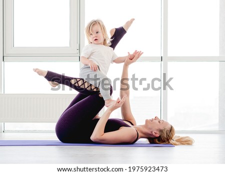 Family yoga with child. Mother exercising with her son at home