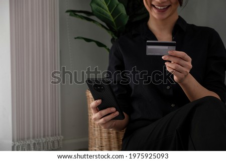 Asian girl making online payment using smartphone for shopping at home