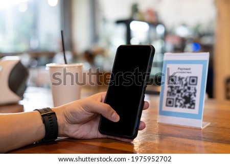 Men use phones to scan a qr code to select a menu or scan to receive a discount or pay for food and drink inside a cafe. using the phone to transfer money or pay online without cash concept.