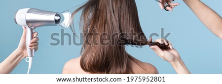 Woman getting a haircut and blow drying her hair Royalty-Free Stock Photo #1975952801