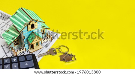 The concept of mortgage and rental housing and real estate. Mortgage credit lending. House mock up with keys with blueprint on yellow background. Calculator for calculating the cost