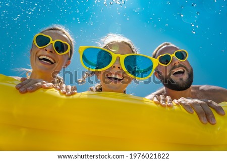 Happy family having fun on summer vacation. Portrait of child, mother and father outdoor against blue sky background. Spring break! Royalty-Free Stock Photo #1976021822