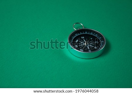 Compass on green background. Concept signs symbols. Tool for travel, tourism,science,get lost, business and design and decoration.