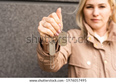 Identification badges, woman holding an army badge