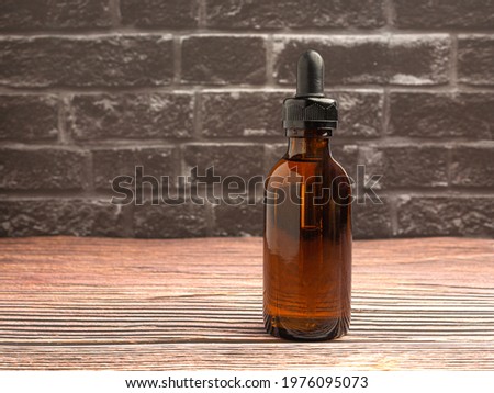 Bottle of cosmetics, natural medicine, essential oils, or other liquids on wooden background with a gray brick wall, Close-up photo. Space for text.