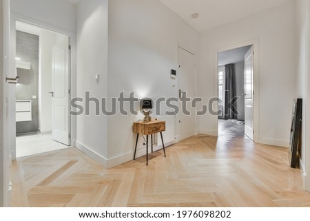 Minimalist style interior design of hallway with parquet floor and doors leading to rooms in modern apartment with geometric design Royalty-Free Stock Photo #1976098202