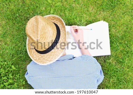 A picture of a woman taking notes on grass