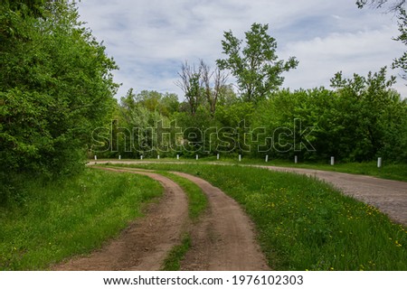 Old granite stone road and dirt road in the countryside. Natural background. Spring season, May. Web banner.