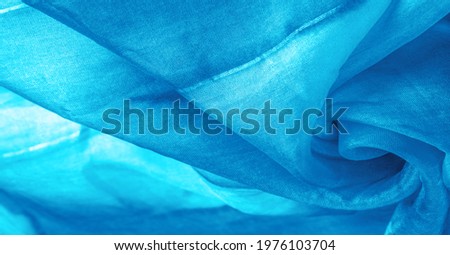 Blue fabric streaked with gray spots on a turquoise background. Abstract designer fabric fancy designer. Beautiful background for your design. Texture. Picture. drawing, pattern, figure