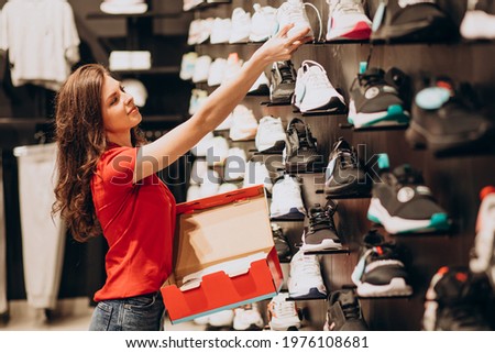 Young woman working at sportswear shop Royalty-Free Stock Photo #1976108681