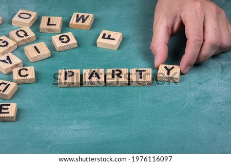 Party. Wooden alphabet letters on a green blackboard background.