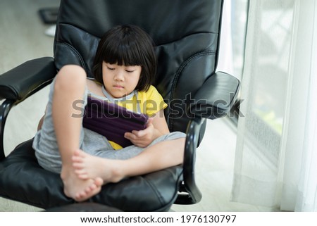 kid is addicted to tablet, little girl playing smartphone, kid use telephone, watching cartoon
