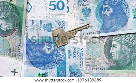 conceptual photo showing apartment key with money background. Taking a mortgage. Financing the purchase of a house or flat. The key to the apartment against the background of Polish zlotys