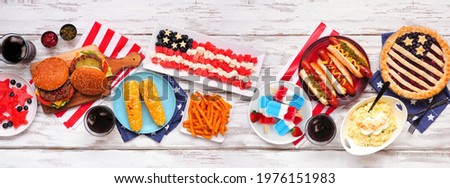 Fourth of July, patriotic, American themed food. Top view table scene on a white wood banner background.