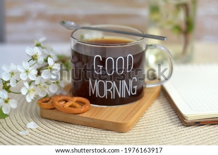 Cup of coffee on wooden board with text good morning with tasty cookies with  apples branch  blossom flower. Spring blossoming. 