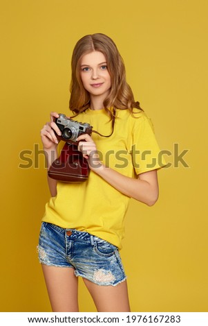 curly blonde woman holding retro vintage photo camera