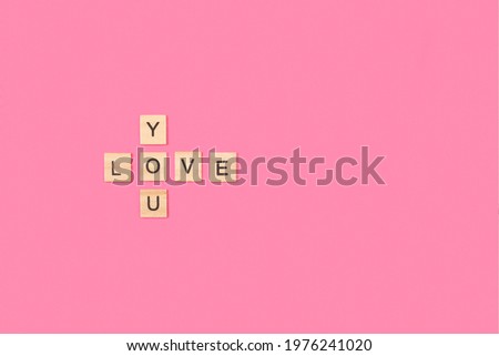 Love you write with wooden letter blocks on a pink background