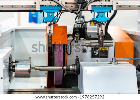 Metal shaft part or workpiece set on high precision automatic surface cylindrical cnc grinding machine for manufacturing finishing process of automobile industrial with automation system robot grip Royalty-Free Stock Photo #1976257292