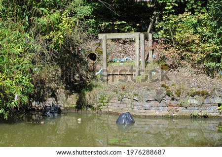 Water Outlet Pipe beside Still Waters of Industrial Canal 