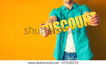 Man holds word Discount on bright colorful background Royalty-Free Stock Photo #197630276