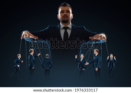 A man, a puppeteer, controls the crowd with threads. The concept of world conspiracy, world government, manipulation, world control Royalty-Free Stock Photo #1976333117
