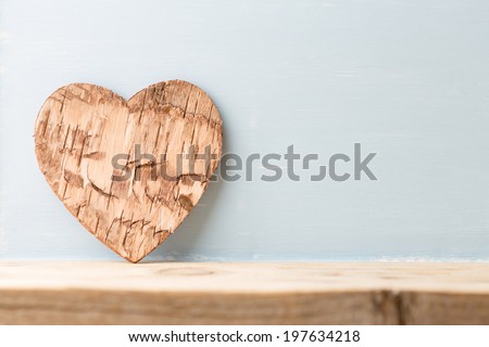 Bark heart on wooden background. Studio photography.