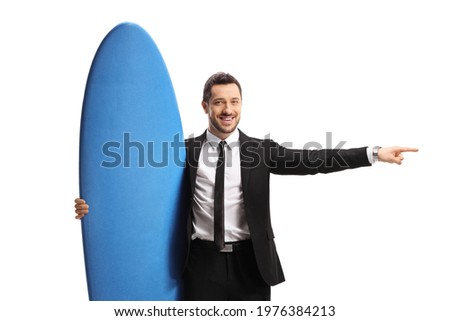 Businessman holding a surfing board and pointing to the side isolated on white background