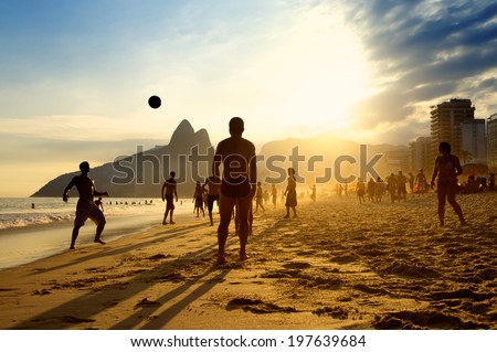 Rio de Janeiro beach football silhouettes of Brazilians playing keepy uppy altinho soccer on the sunset shore at Posto Nove Ipanema Beach