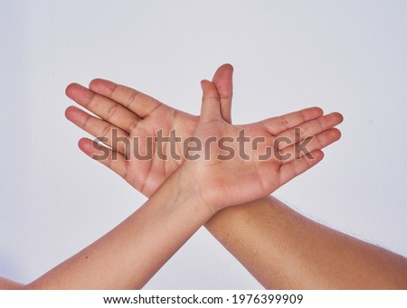 Latin adult man hand gesturing with the hand of a child on a white background