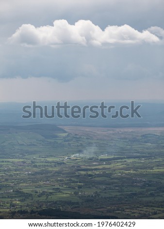 Overlooking at a plain and hills, rural landscape view from a mountain. Flatland landscape, a cloudy sky over plain or flat land, fabric pollution, global warming, CO2 emission, concept