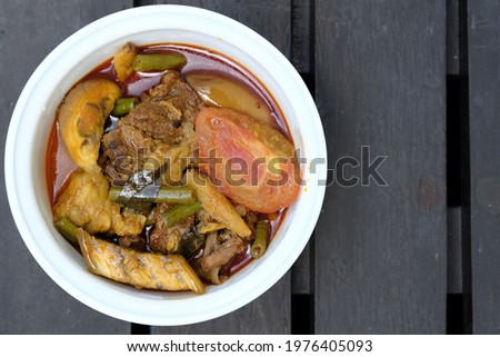 Flatlay and selective focus picture of beef dalca served during Eid Mubarak. Dalca is a stewed vegetable curry with lentils add meat that is famously served with briyani and tomato rice.