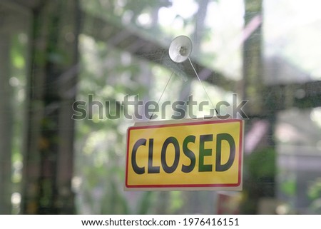 Closed signboard hanging on glass door of a restaurant. Copy space.