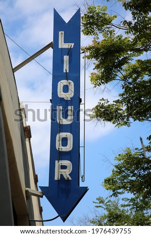 Neon Liquor Sign. Blue Neon Liquor arrow sign leading to the door of a Liquor Store. Liquor is enjoyed world wide. 